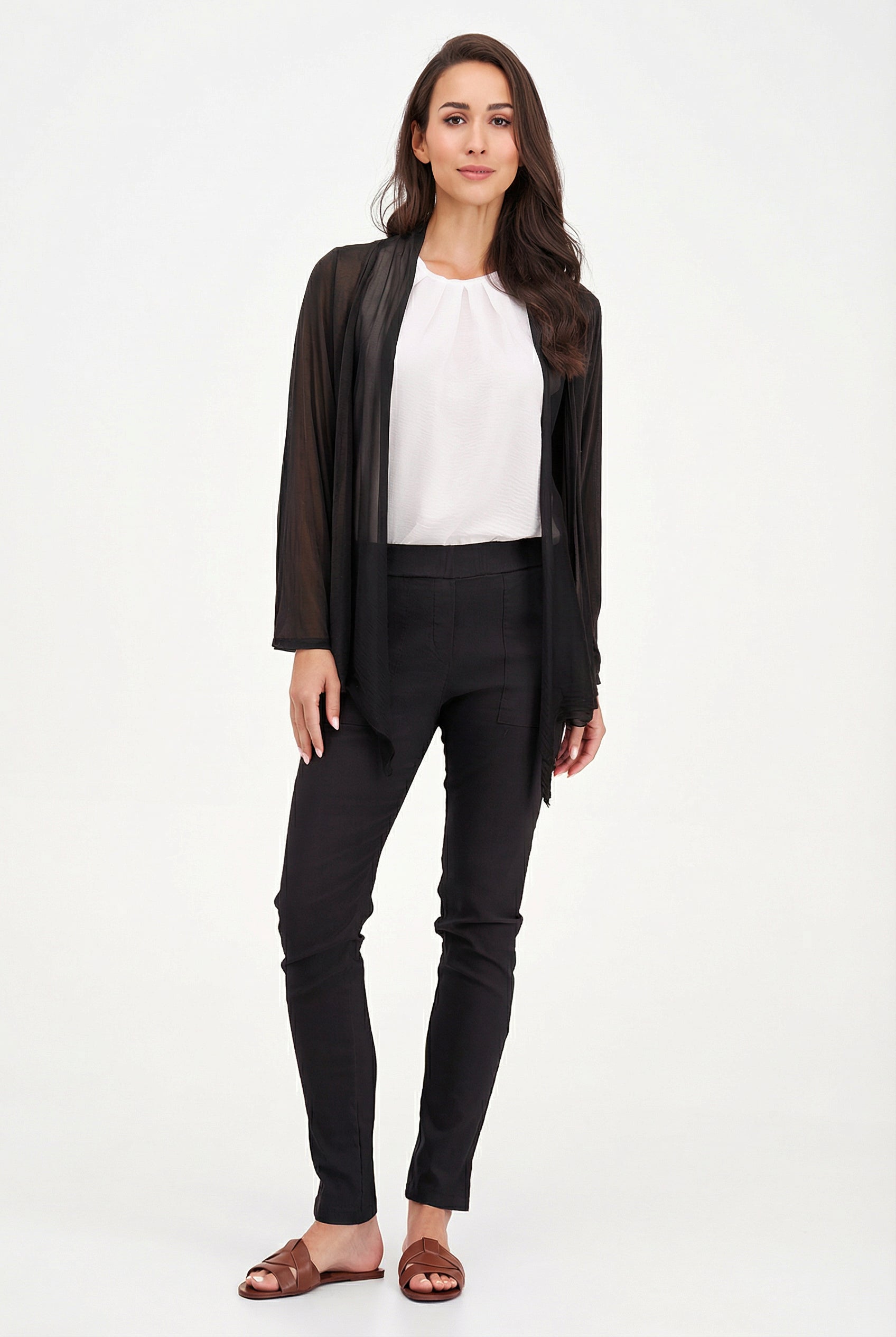 Woman wearing a black cardigan, white shirt, and black pants on a white background